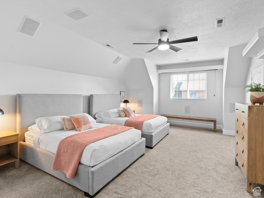 Bedroom with lofted ceiling, light carpet, baseboards, and visible vents
