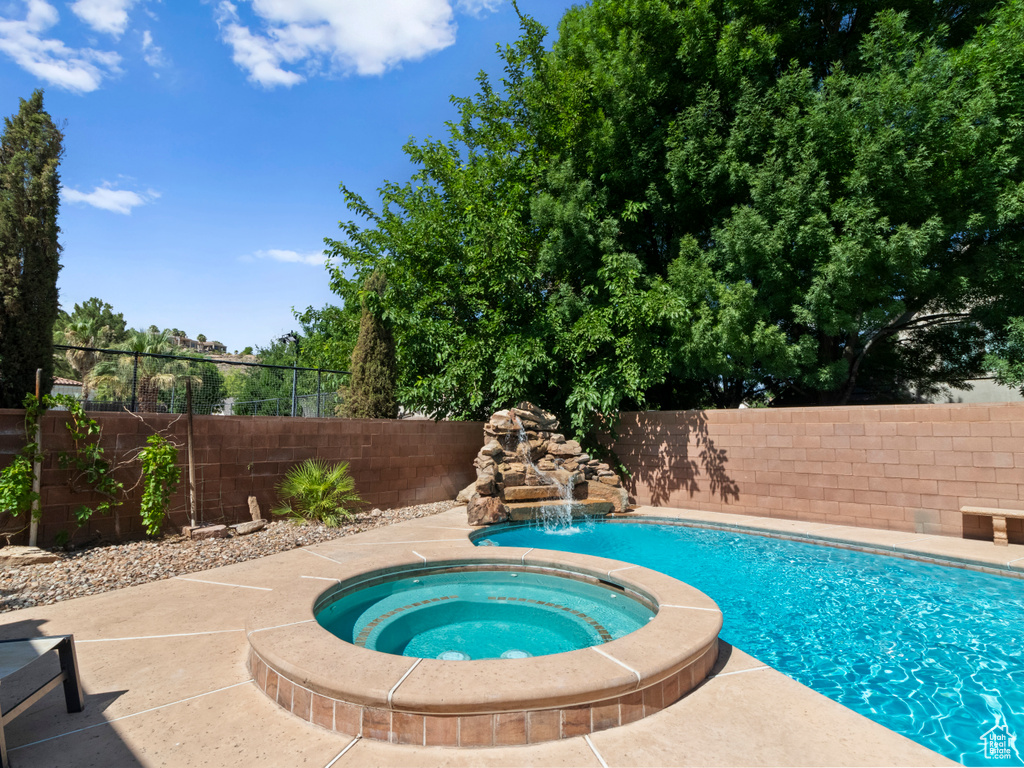 View of pool featuring a fenced in pool, a fenced backyard, and an in ground hot tub