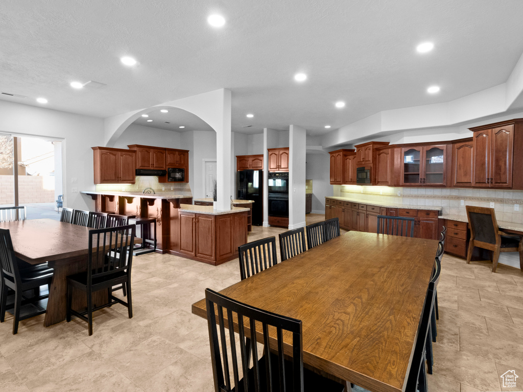 Dining space featuring arched walkways and recessed lighting
