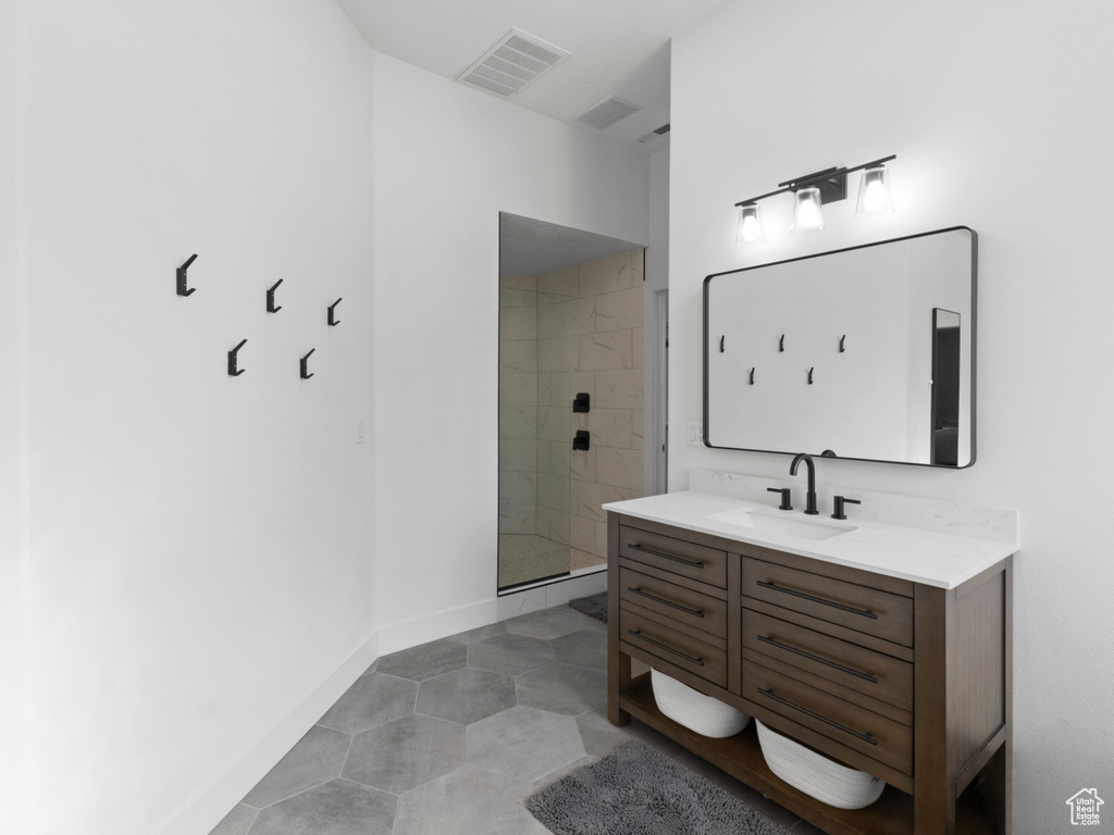 Full bath featuring a shower stall, vanity, and visible vents