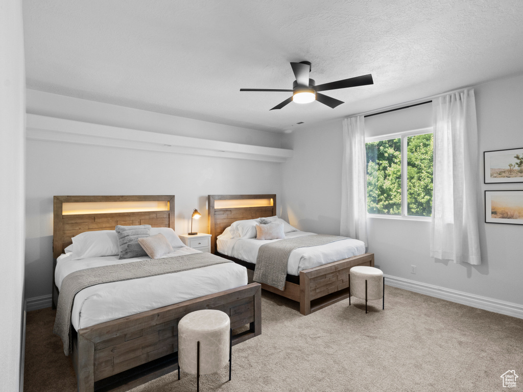 Carpeted bedroom featuring baseboards and ceiling fan