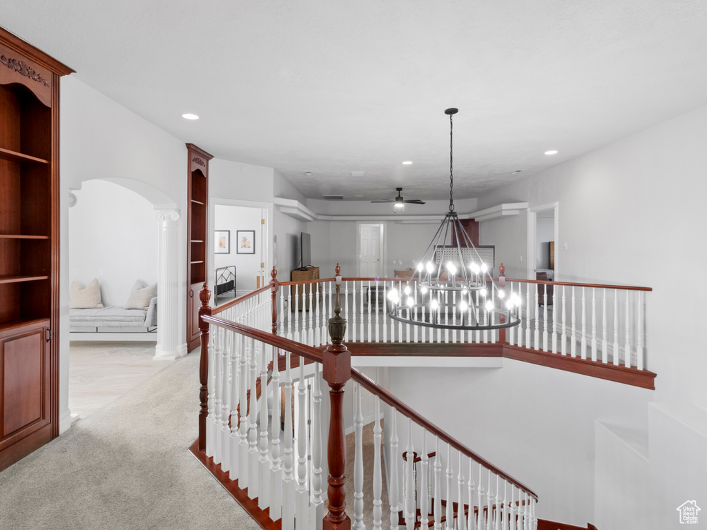 Hallway featuring recessed lighting, an upstairs landing, arched walkways, a chandelier, and light colored carpet