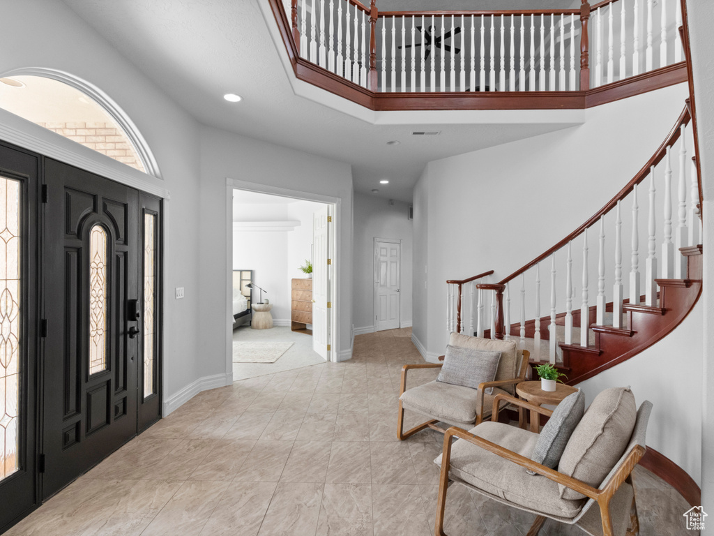 Foyer entrance with stairs, a towering ceiling, and recessed lighting