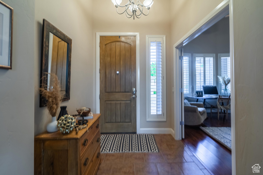 Entryway featuring baseboards and a notable chandelier
