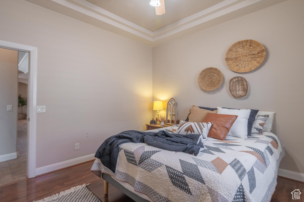 Bedroom featuring wood finished floors, baseboards, and ceiling fan