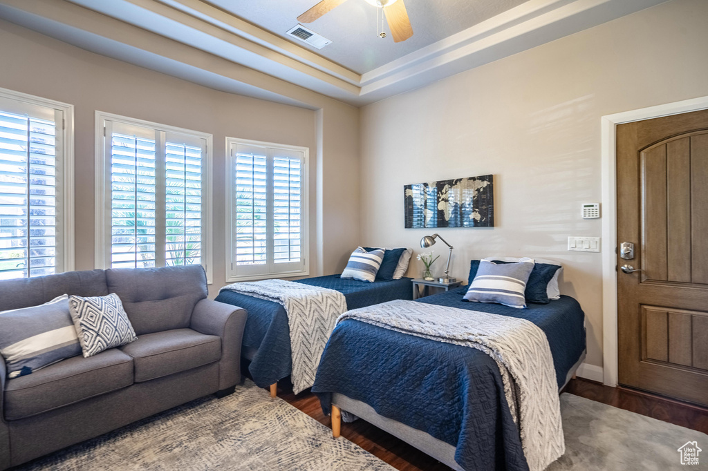 Bedroom featuring baseboards, a ceiling fan, wood finished floors, and visible vents