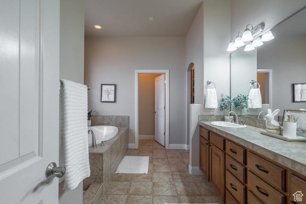Bathroom featuring a garden tub, vanity, and recessed lighting