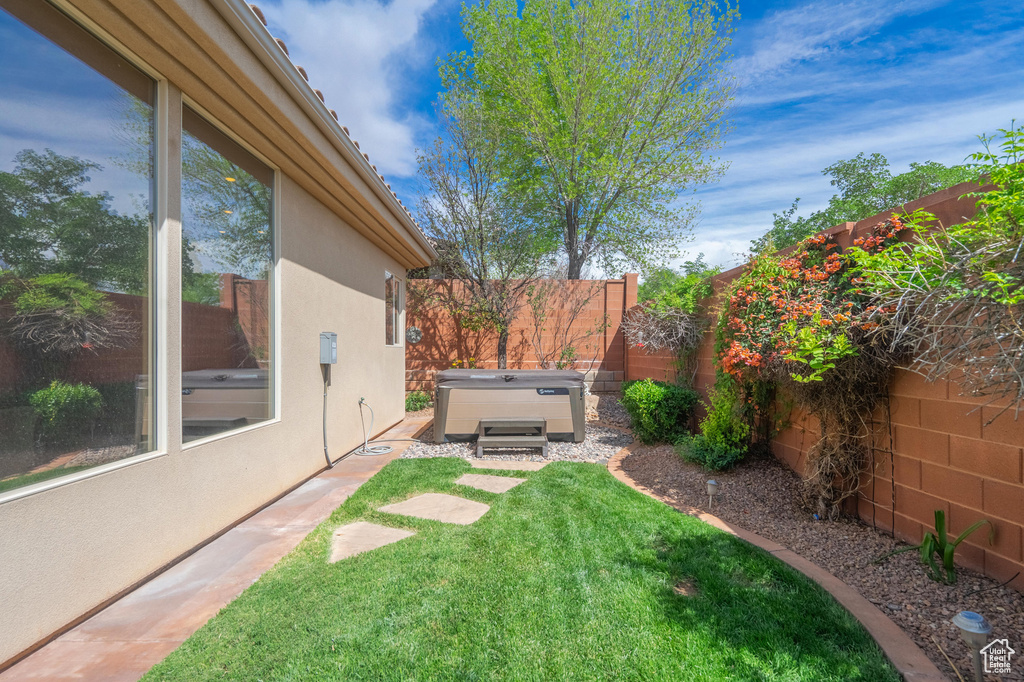 View of yard with a fenced backyard, a hot tub, and a patio