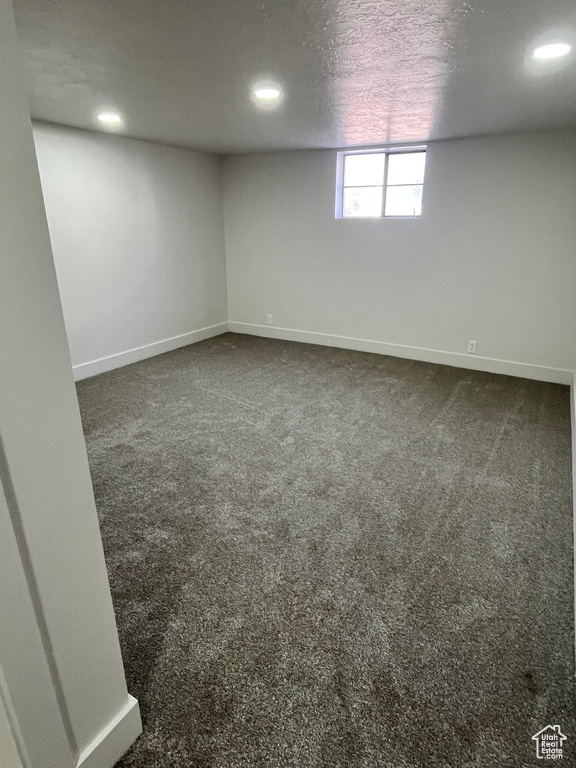 Basement with baseboards, dark carpet, and recessed lighting