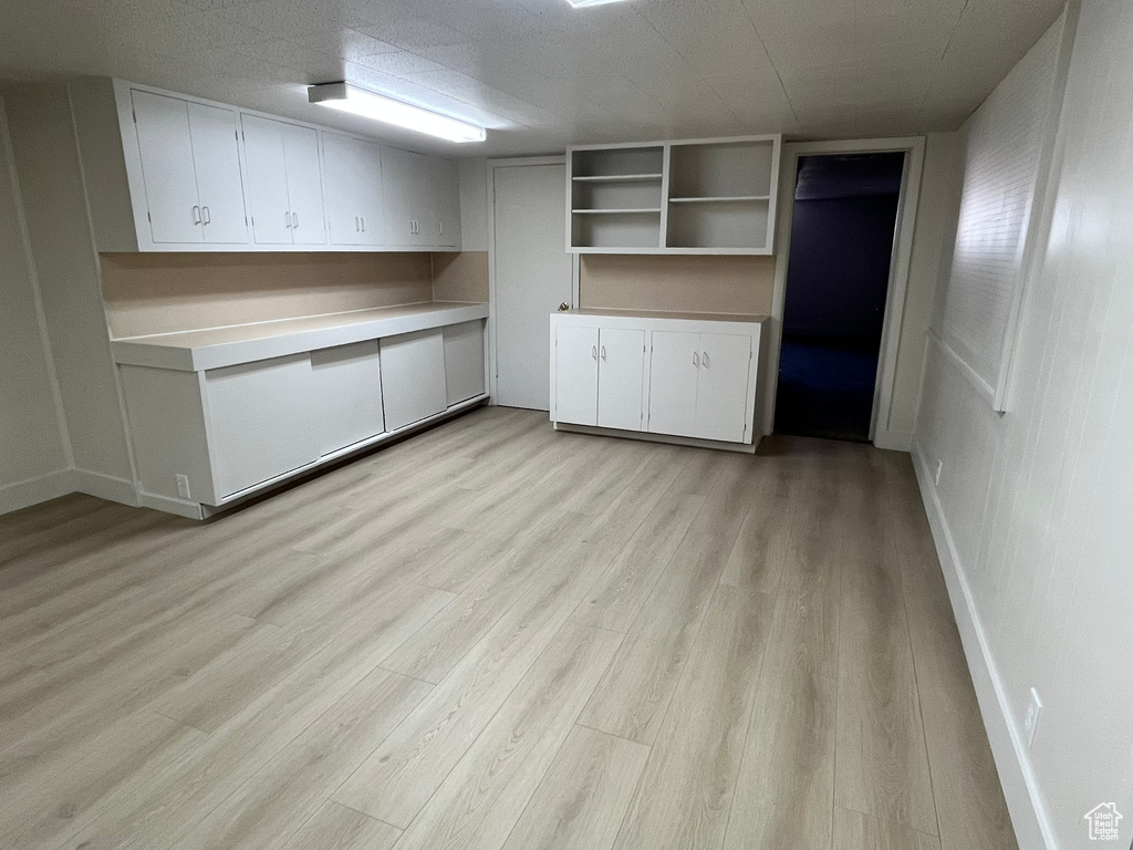 Finished basement with baseboards and light wood-type flooring