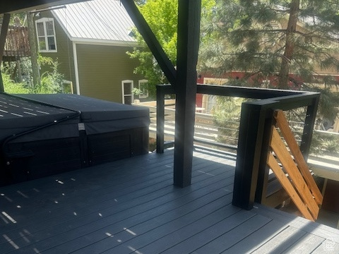 Wooden deck featuring a covered hot tub