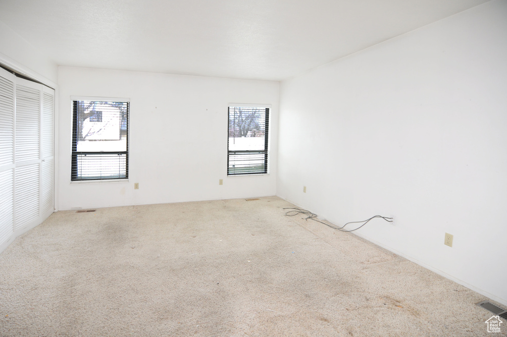 Carpeted spare room with plenty of natural light and visible vents