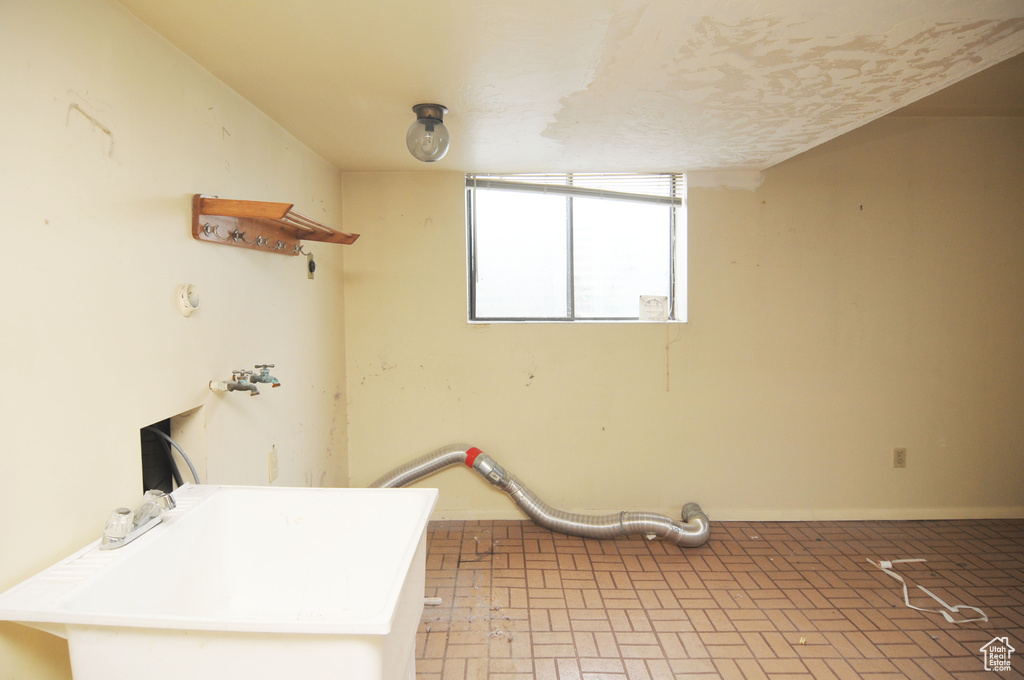 Laundry area with brick floor, a sink, and laundry area