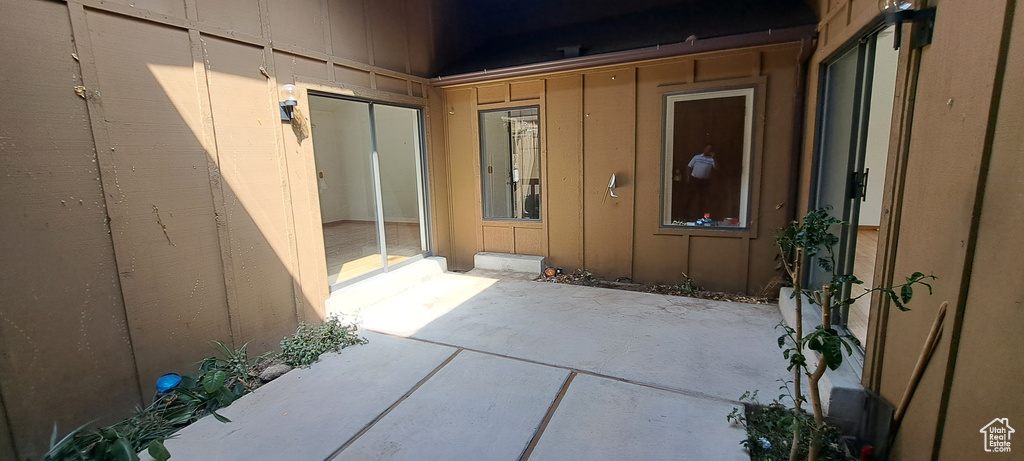 View of exterior entry with a patio and board and batten siding