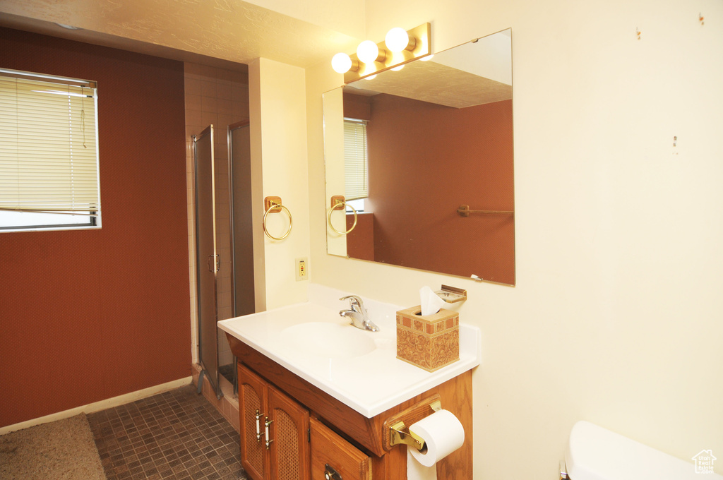 Bathroom featuring an enclosed shower, baseboards, toilet, and vanity