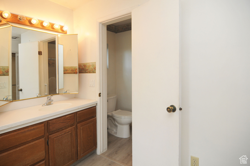 Bathroom with wood finished floors, toilet, and vanity