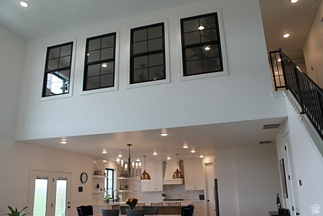 Interior space featuring stairway, an inviting chandelier, a towering ceiling, and recessed lighting