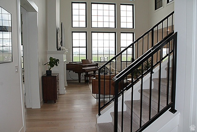 Entryway with baseboards, wood finished floors, a towering ceiling, and stairs