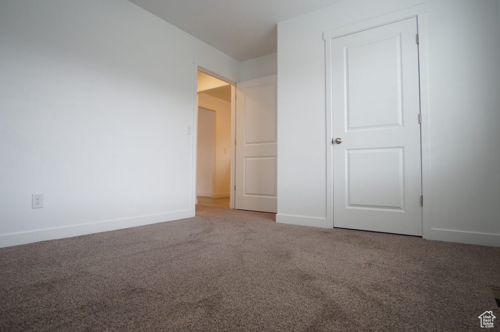 Unfurnished bedroom featuring carpet flooring and baseboards