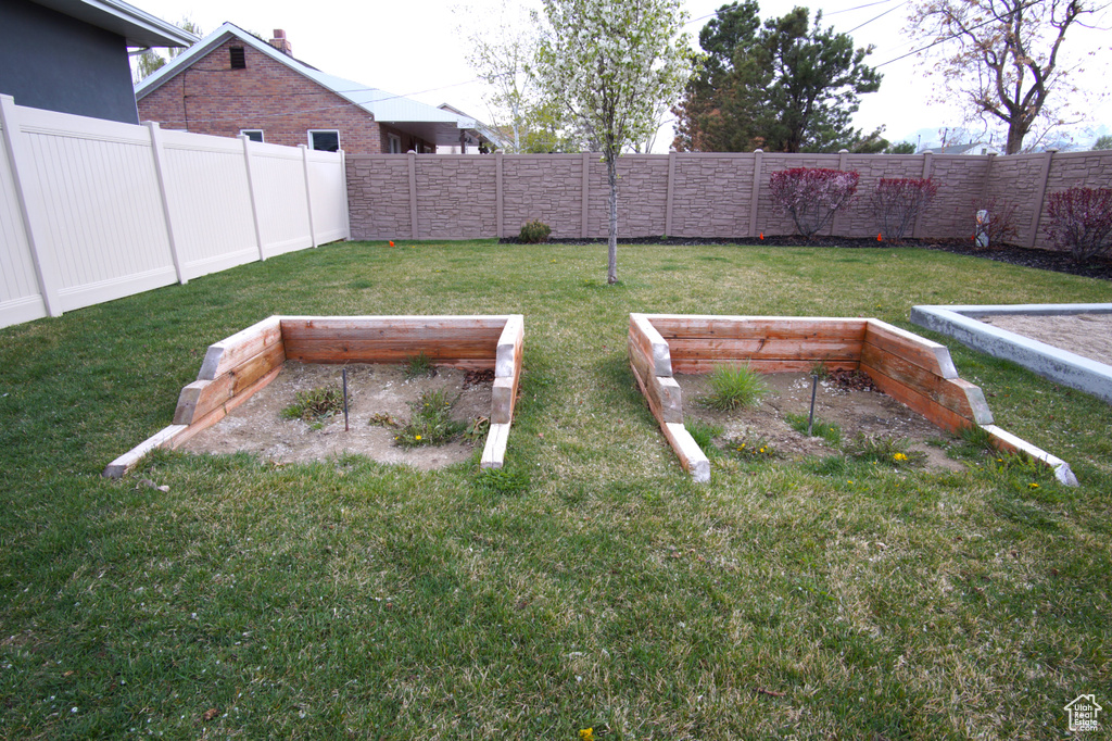 View of yard with a fenced backyard and a vegetable garden