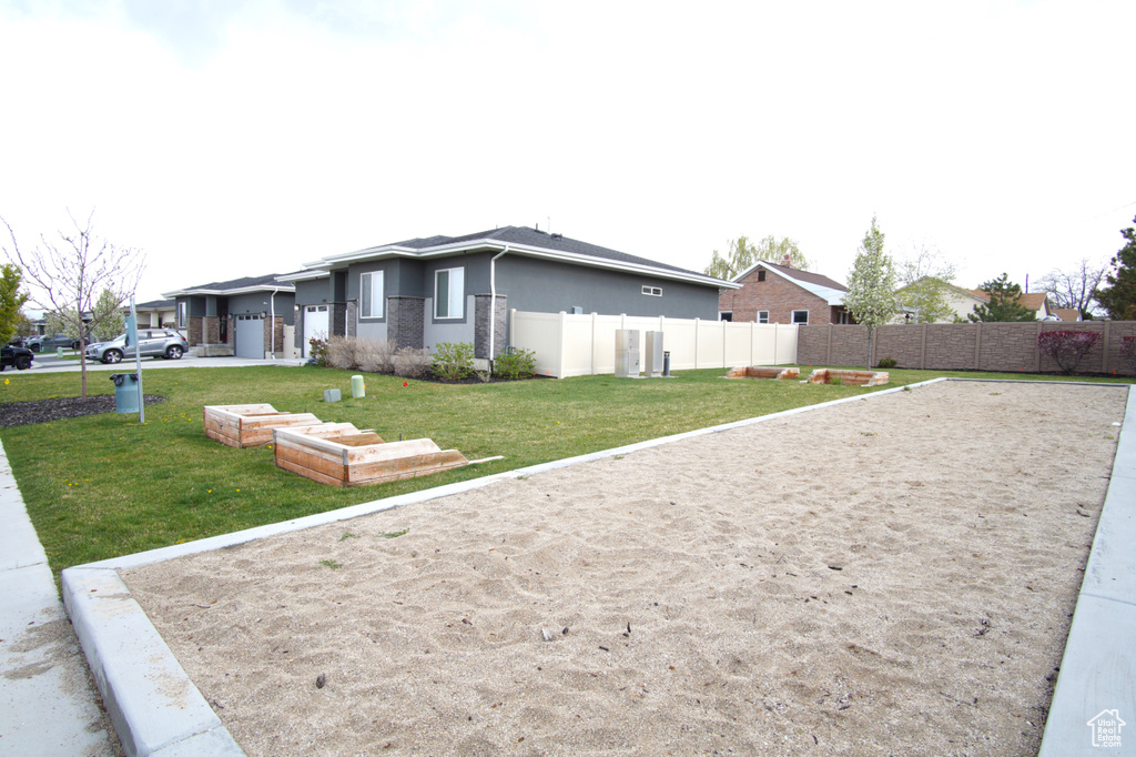 View of property exterior featuring stucco siding, a yard, and fence