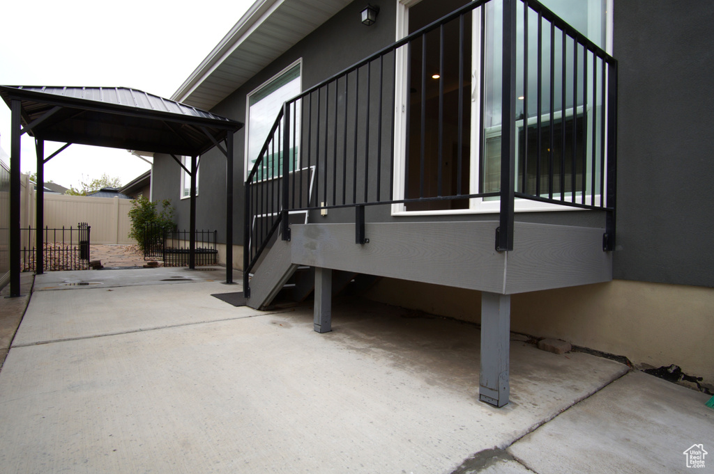 View of side of home featuring fence and a gazebo