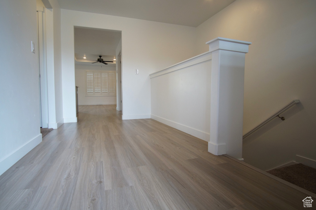 Interior space with wood finished floors, a ceiling fan, and baseboards