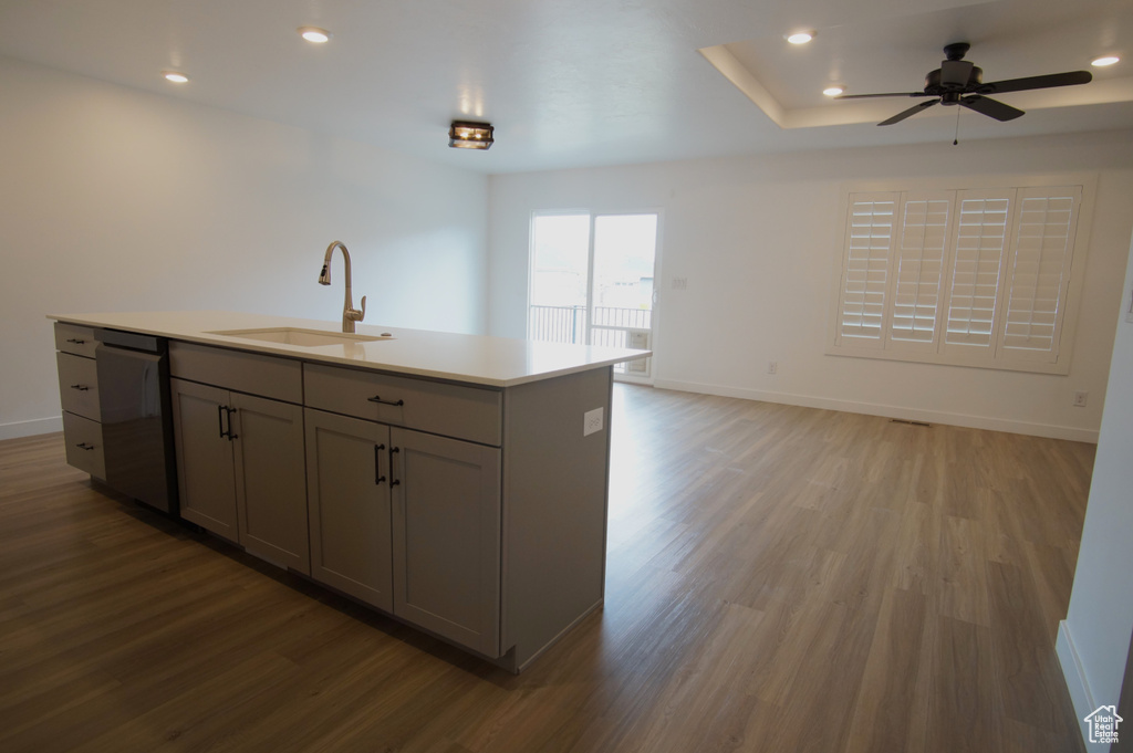 Kitchen with dishwasher, gray cabinets, light wood-type flooring, and a sink