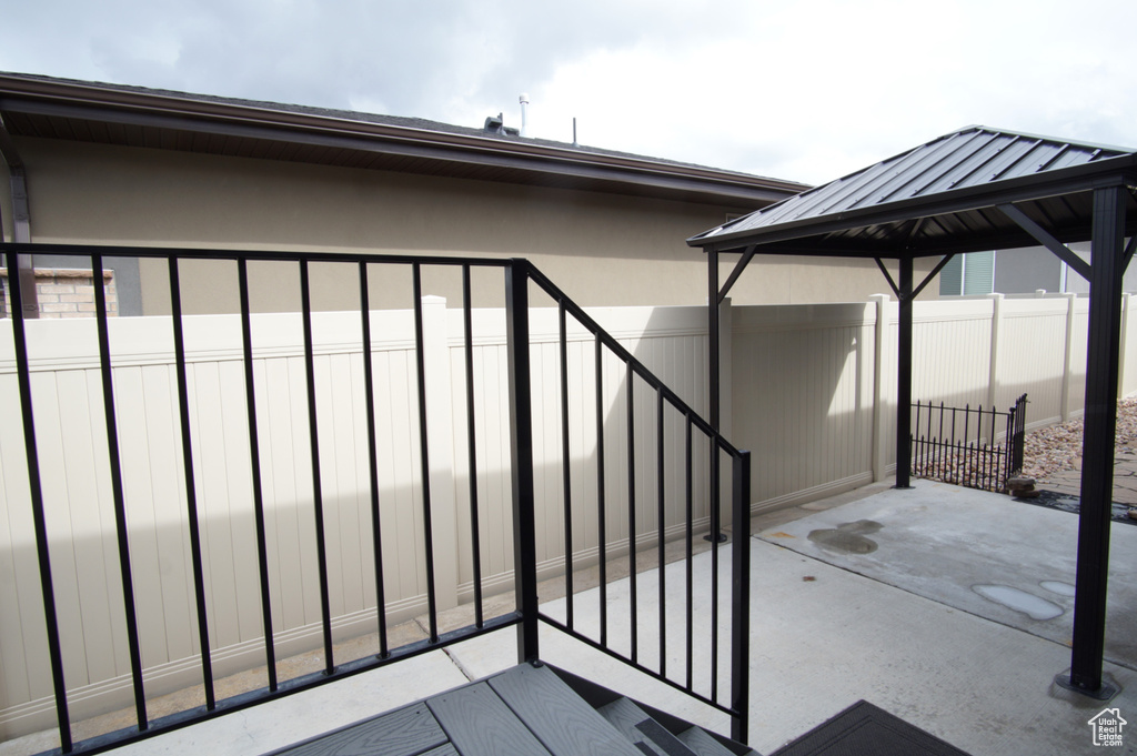 View of patio featuring fence and a gazebo