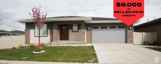 Prairie-style home with a garage, concrete driveway, and stone siding