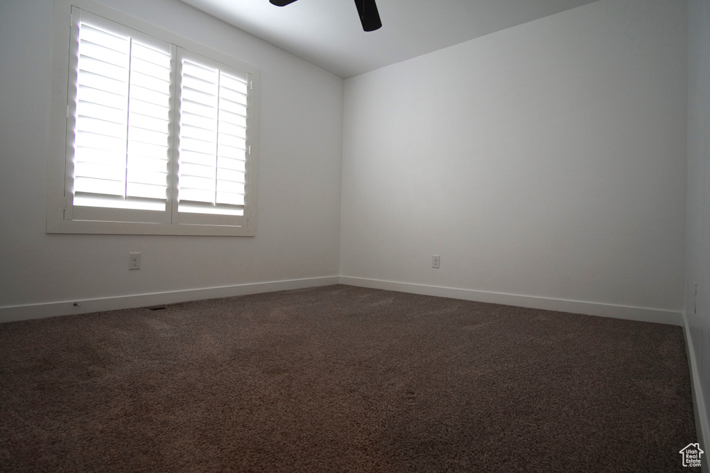 Empty room featuring baseboards, carpet, and ceiling fan