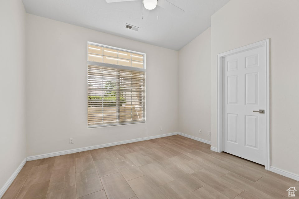 Unfurnished room with a ceiling fan, light wood-style flooring, and baseboards