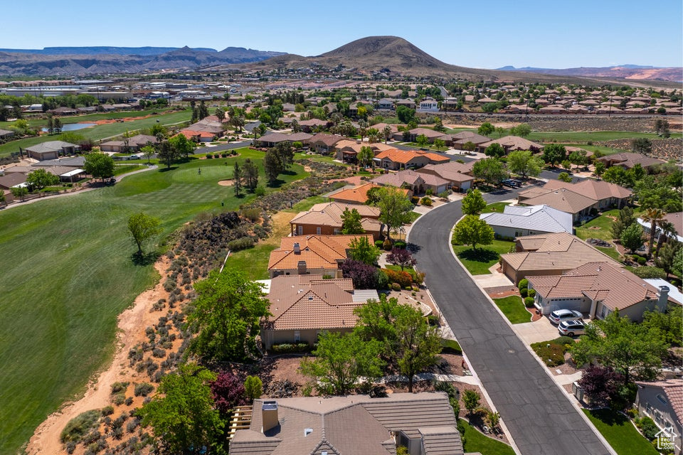 Aerial perspective of suburban area with a mountain backdrop and a local golf course