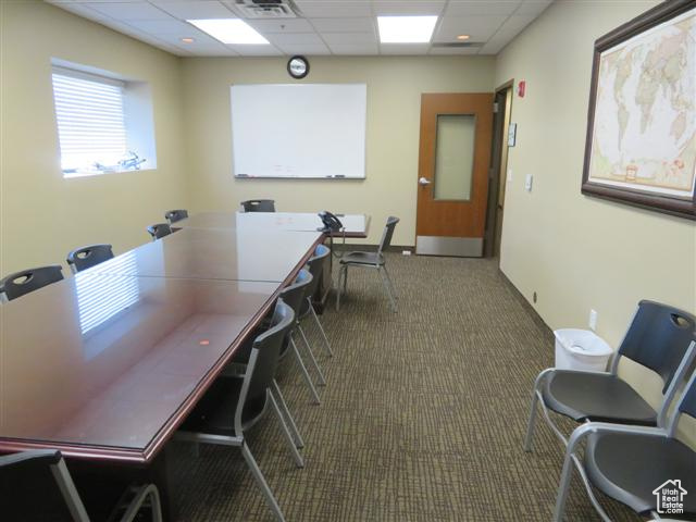 Office with visible vents, baseboards, a paneled ceiling, and carpet flooring