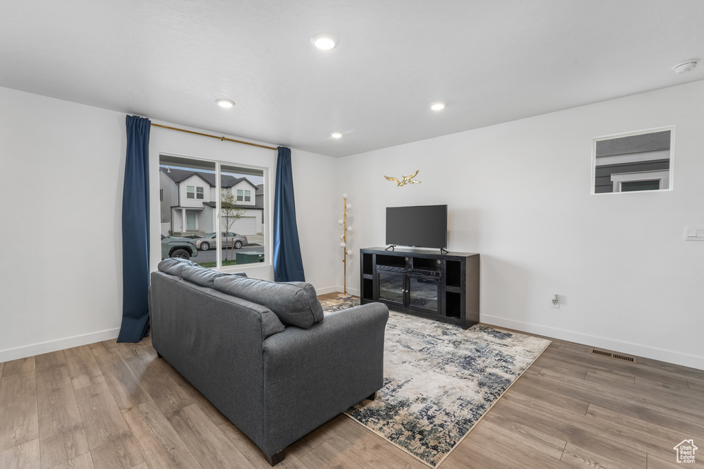 Living room with baseboards, wood finished floors, visible vents, and recessed lighting