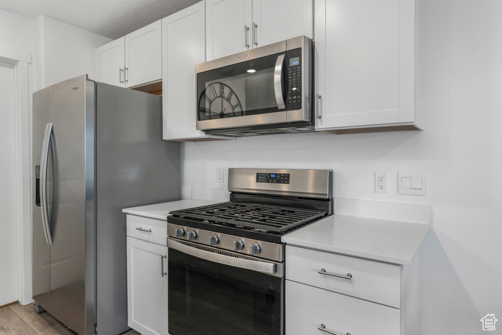 Kitchen featuring light countertops, white cabinetry, and appliances with stainless steel finishes