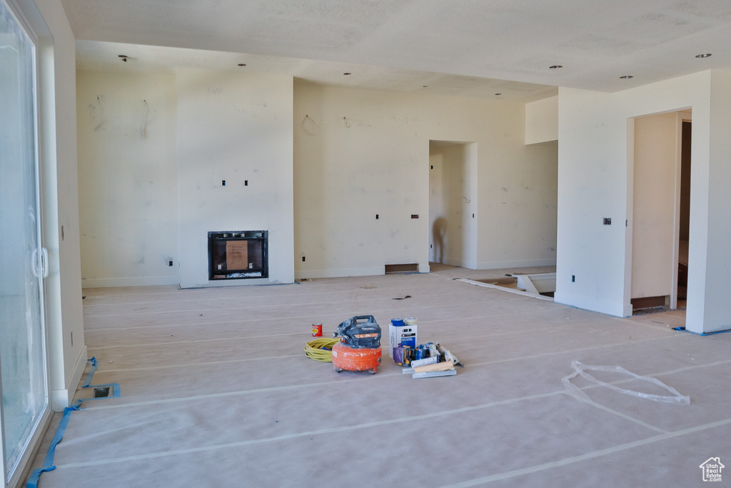 Unfurnished living room featuring a fireplace and heating unit