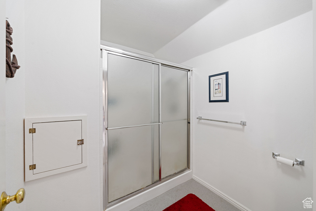 Bathroom featuring baseboards and a shower with shower door