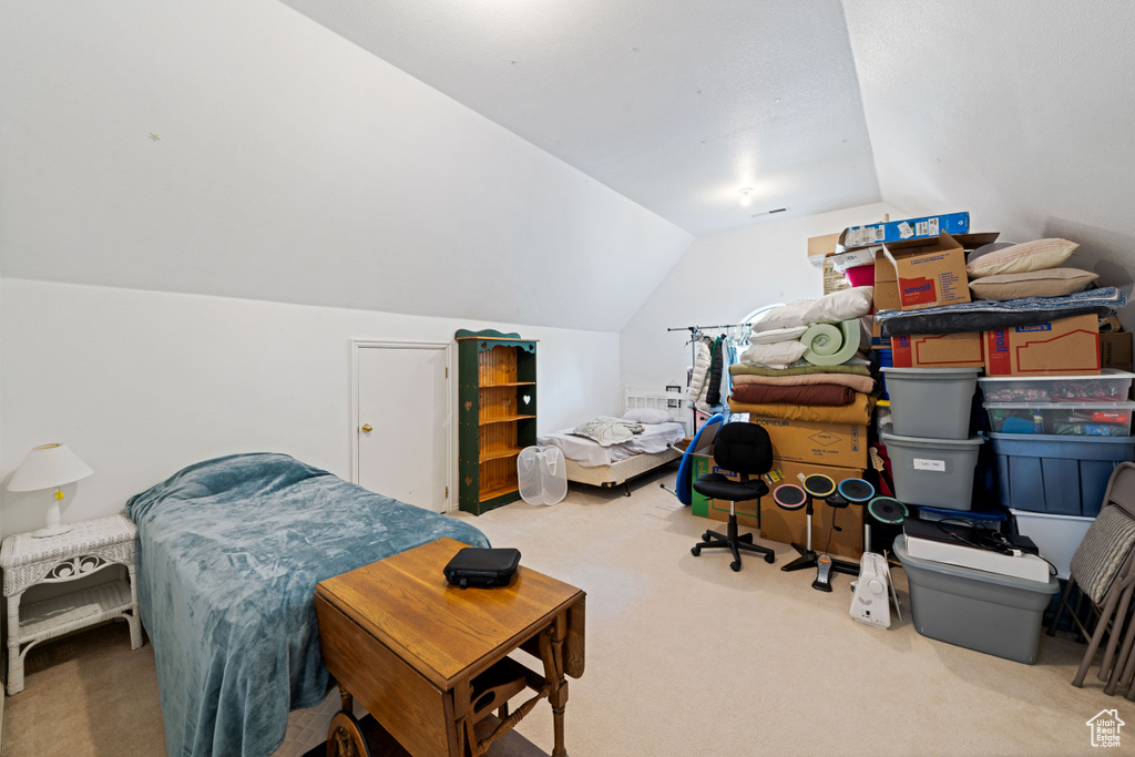 Bedroom featuring lofted ceiling and carpet floors