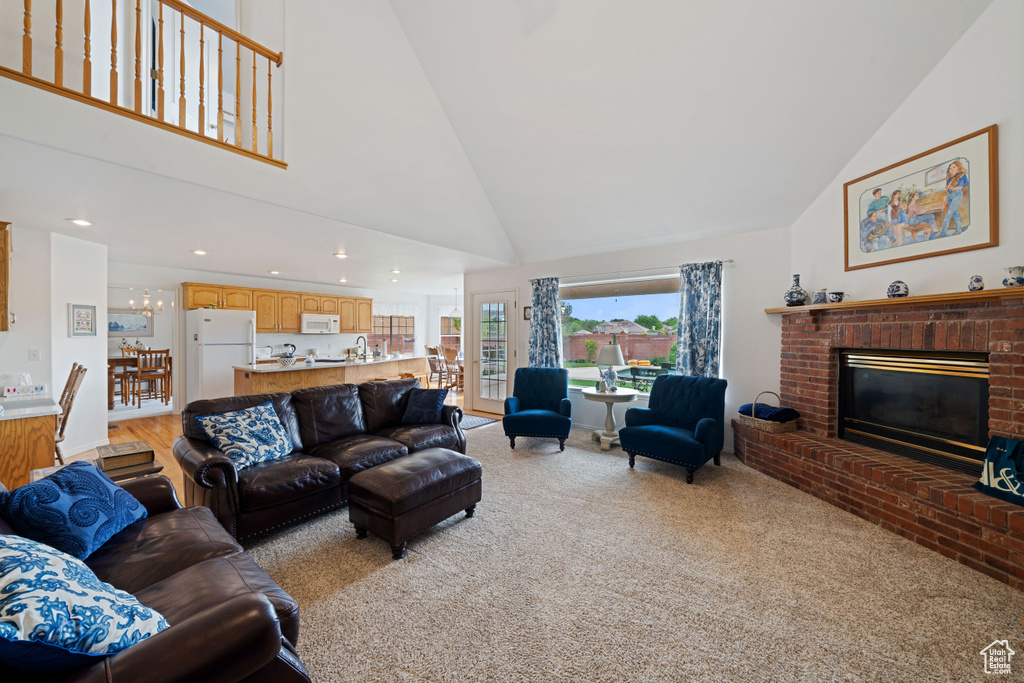 Living room with high vaulted ceiling, recessed lighting, light carpet, and a fireplace