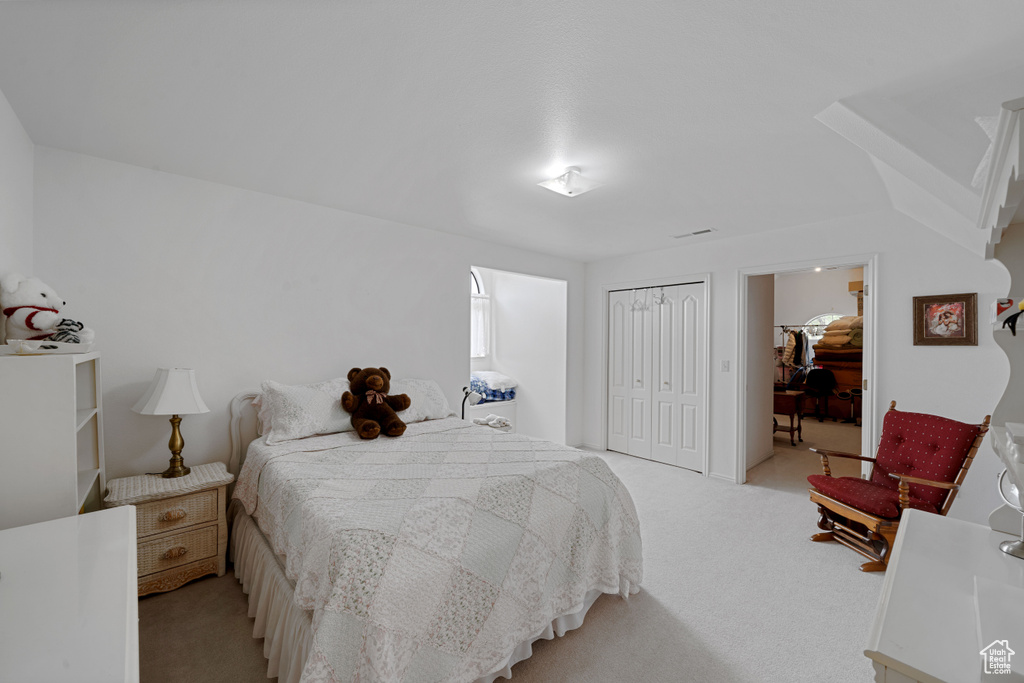 Bedroom featuring carpet flooring and a closet