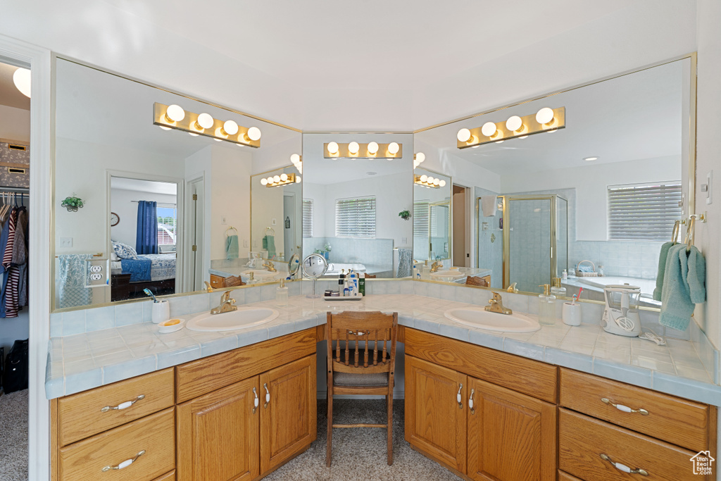 Bathroom featuring a garden tub, vanity, and a stall shower