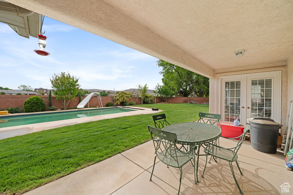 View of patio / terrace with a fenced backyard, a fenced in pool, french doors, and outdoor dining area