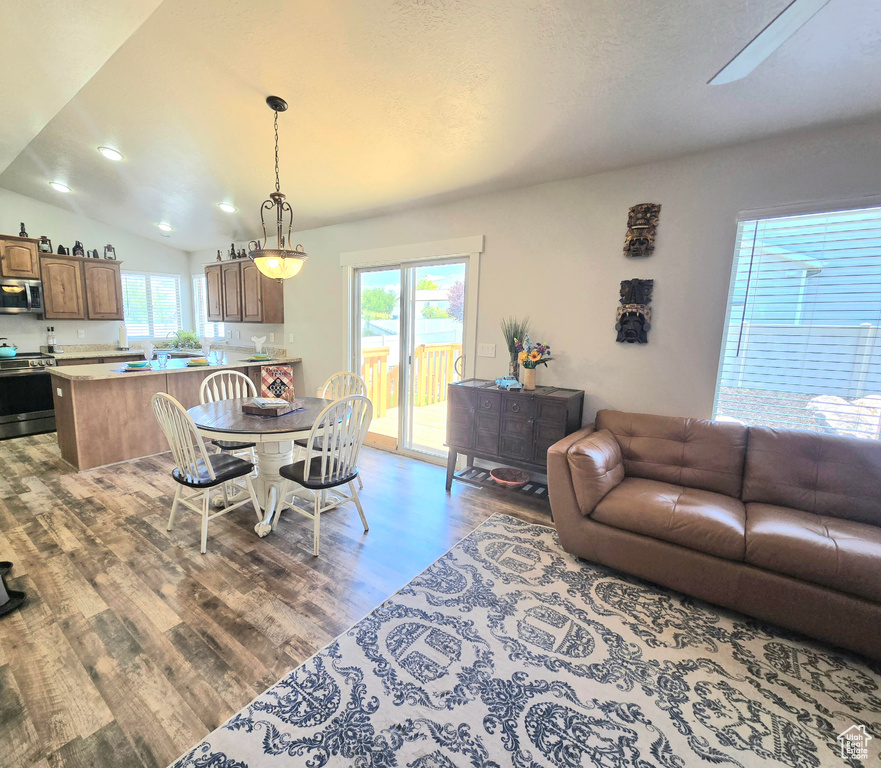 Dining room featuring wood finished floors, lofted ceiling, and recessed lighting