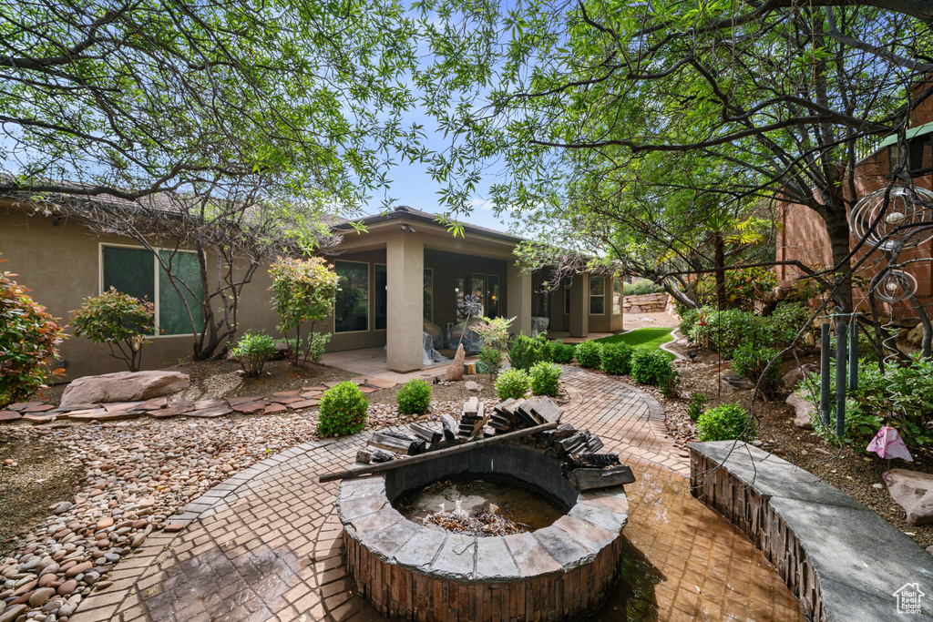 Rear view of house featuring a patio, an outdoor fire pit, and stucco siding