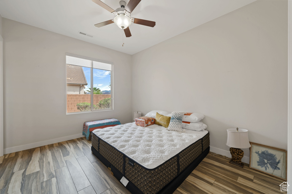 Bedroom featuring wood finished floors, visible vents, a ceiling fan, and baseboards