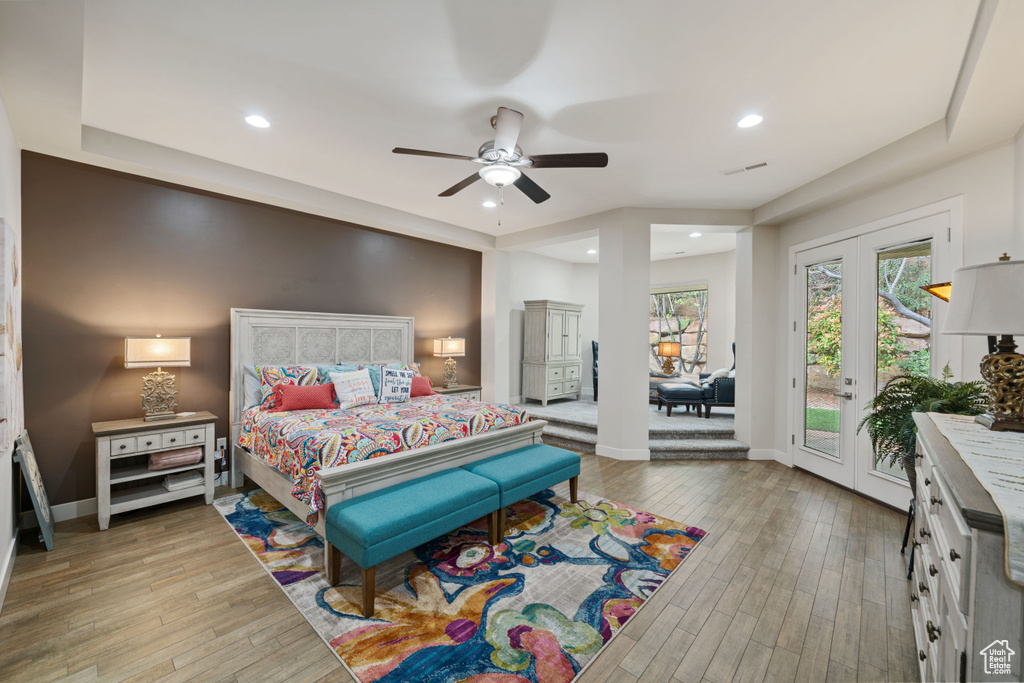 Bedroom with light wood-type flooring, baseboards, and access to outside