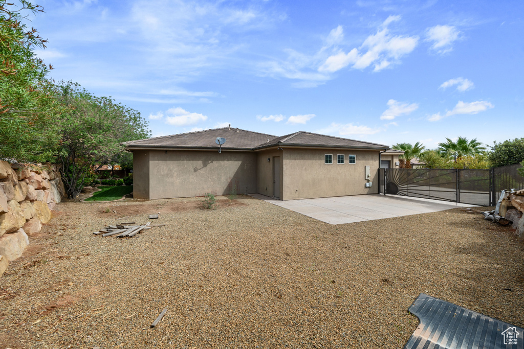 Back of property featuring a patio, stucco siding, and fence