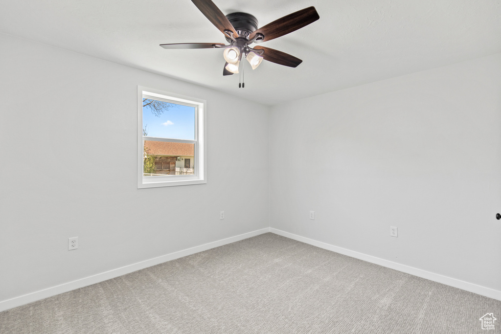 Empty room with baseboards, ceiling fan, and carpet floors