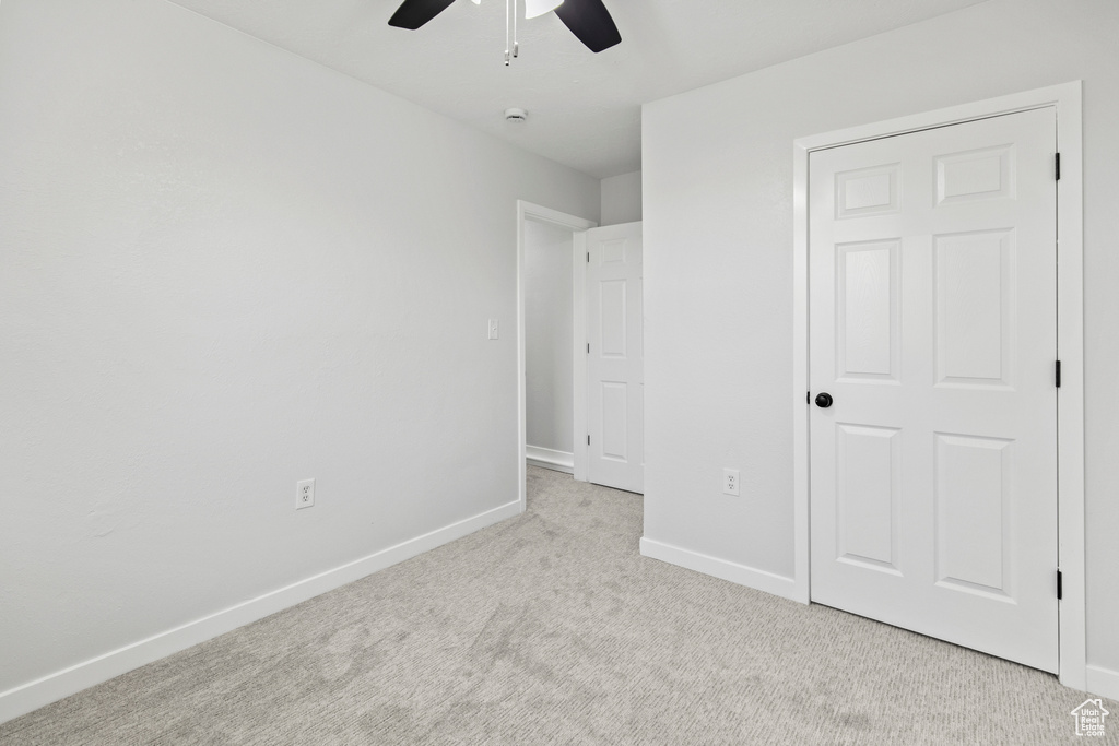 Unfurnished bedroom featuring ceiling fan, carpet floors, and baseboards